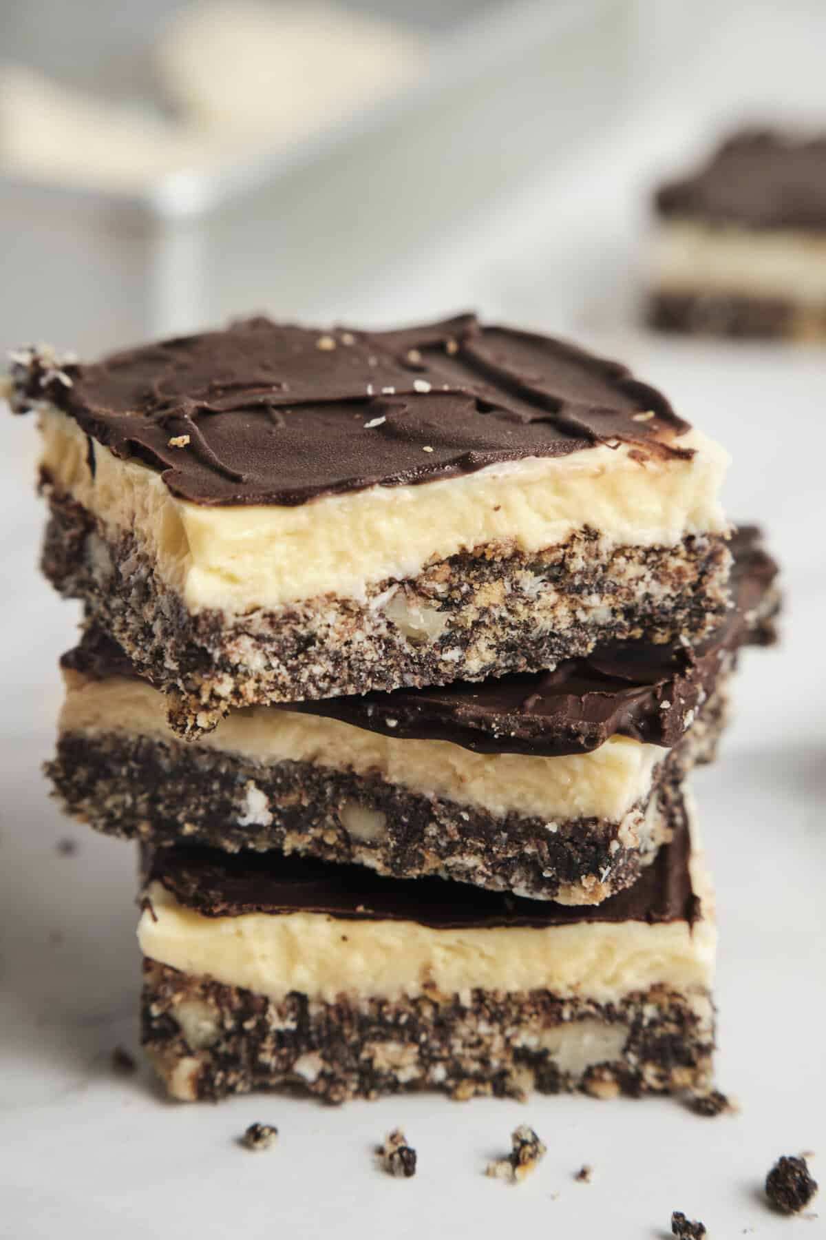 Delicious layered dessert bars with chocolate topping, creamy filling, and crunchy crust, perfect for healthy snacks or indulgent treats, ideal for food and fitness enthusiasts.