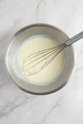 Light whisked eggs in stainless steel bowl, perfect for healthy breakfast recipes or nutritious meal prep, emphasizing balanced eats for a fit lifestyle.