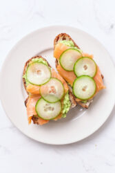 Fresh smoked salmon and cucumber open-faced sandwiches on whole grain bread with guacamole, a healthy and delicious meal idea from Food Faith Fitness.