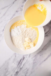 Flour, butter, and eggs in white bowls prepared for healthy baking or cooking; ingredients for nutritious recipes on Food Faith Fitness website.